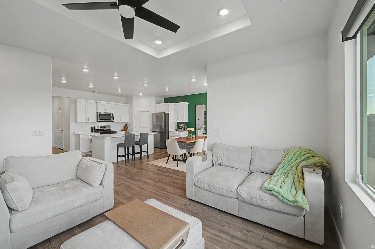 Open-concept living area featuring wood-finish flooring, recessed lighting, and a modern ceiling fan