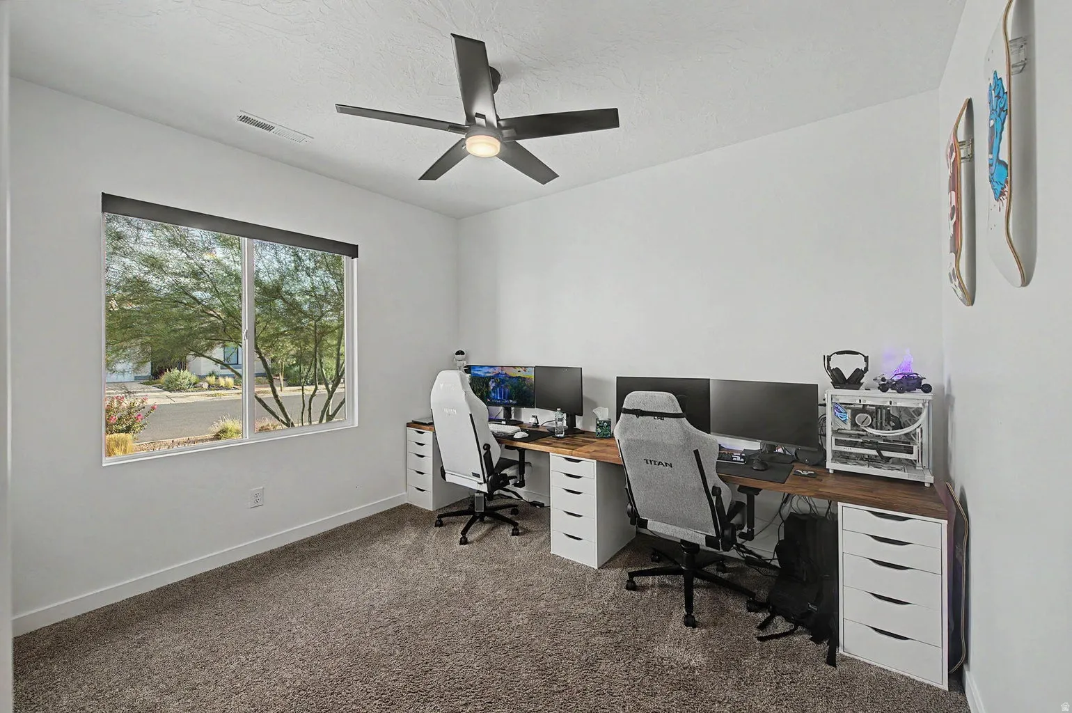 Room featuring a large window, neutral carpeting, and a ceiling fan with integrated lighting