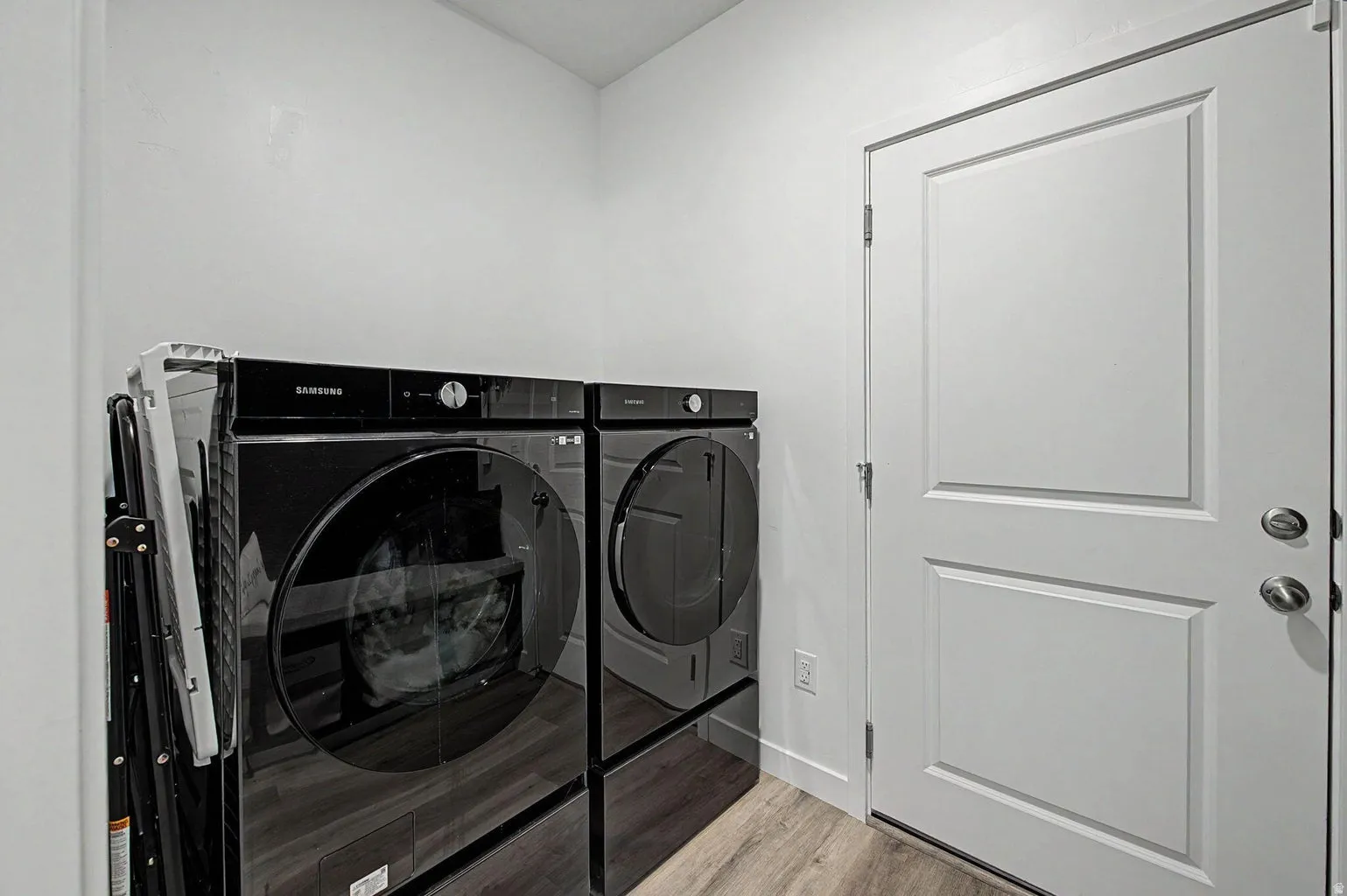 Utility area featuring wood-finish flooring and a white paneled door