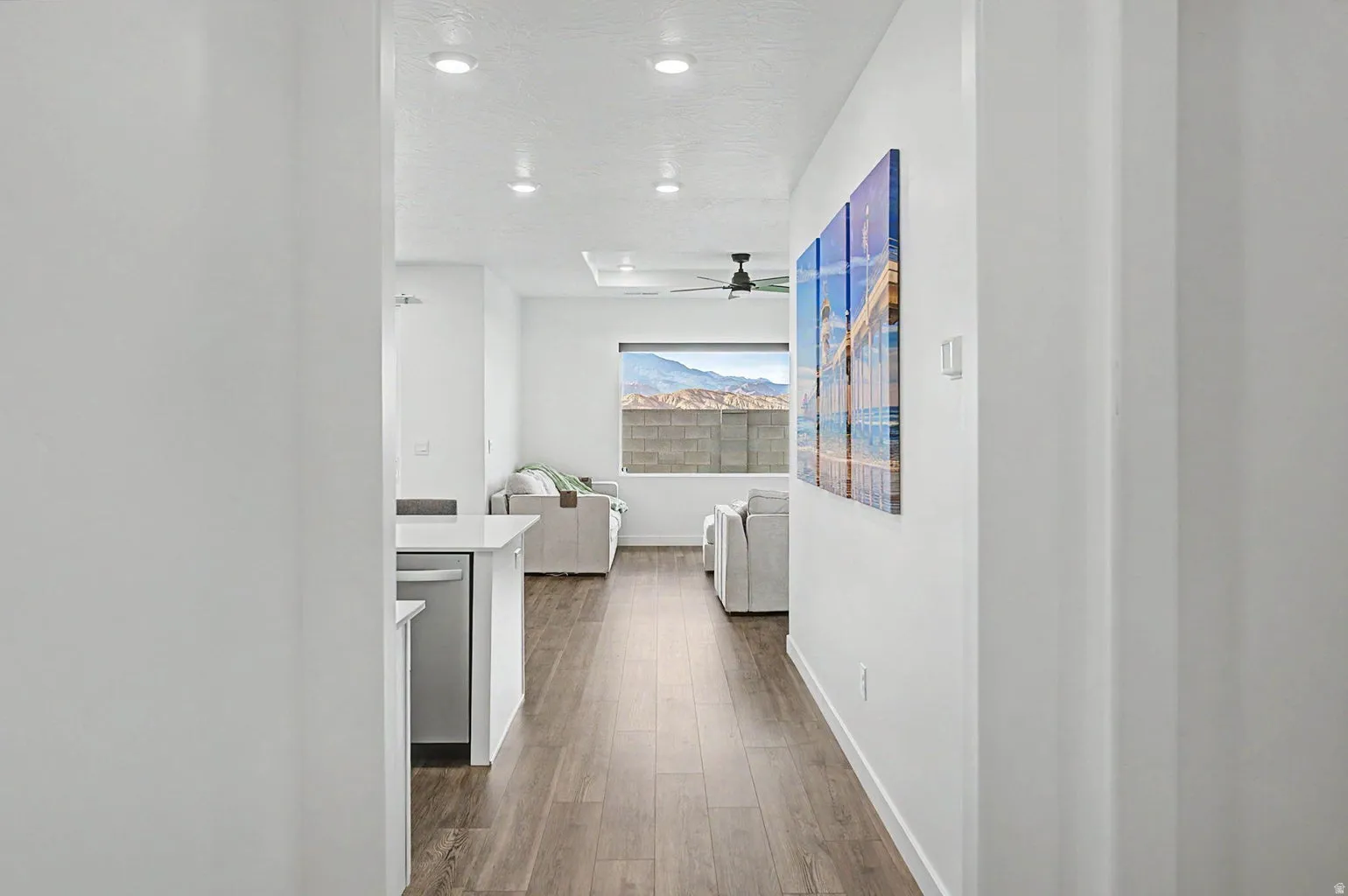 Open-concept living area featuring wood-finish flooring, recessed lighting, and a contemporary ceiling fan