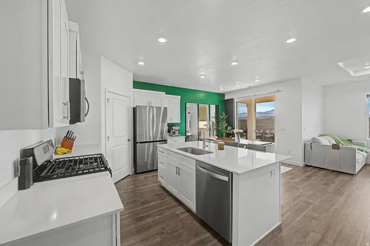 Open-concept kitchen featuring an island with a built-in sink and stainless steel dishwasher