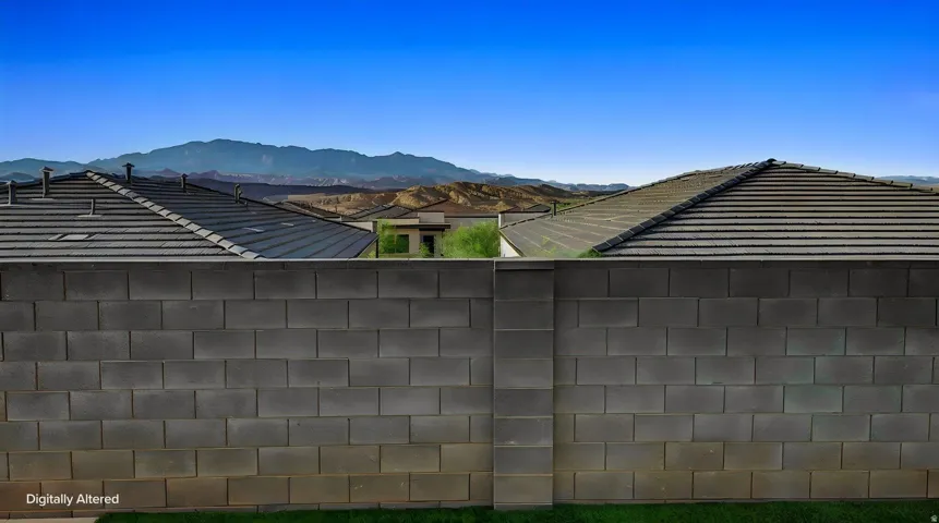 Block wall perimeter with distant mountain scenery under a clear sky