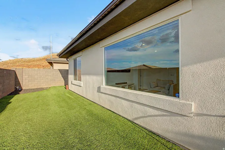 Exterior stucco siding with a prominent large picture window