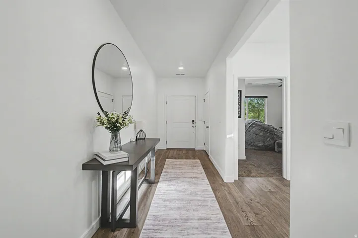 Bright entryway featuring wood-finish flooring, white walls, and recessed lighting