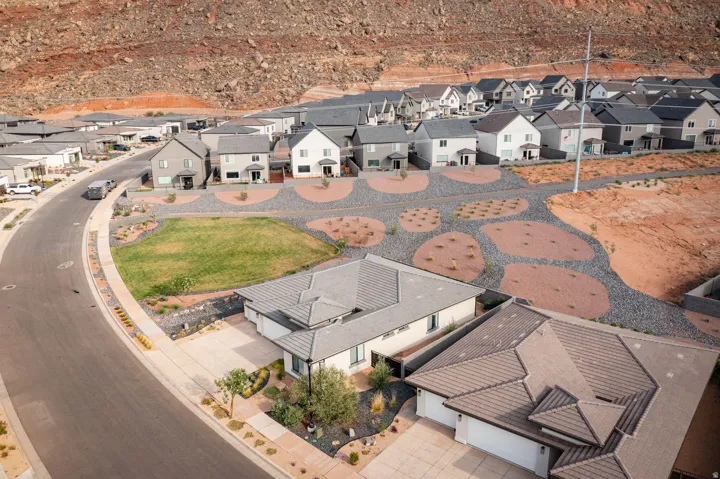 Modern residential development featuring a paved street, desert landscaping, and varied rooflines