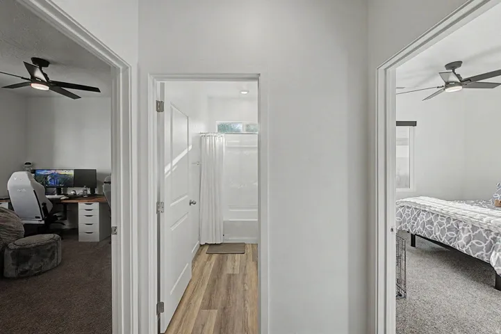 Central hallway featuring wood-finish flooring and white interior doors