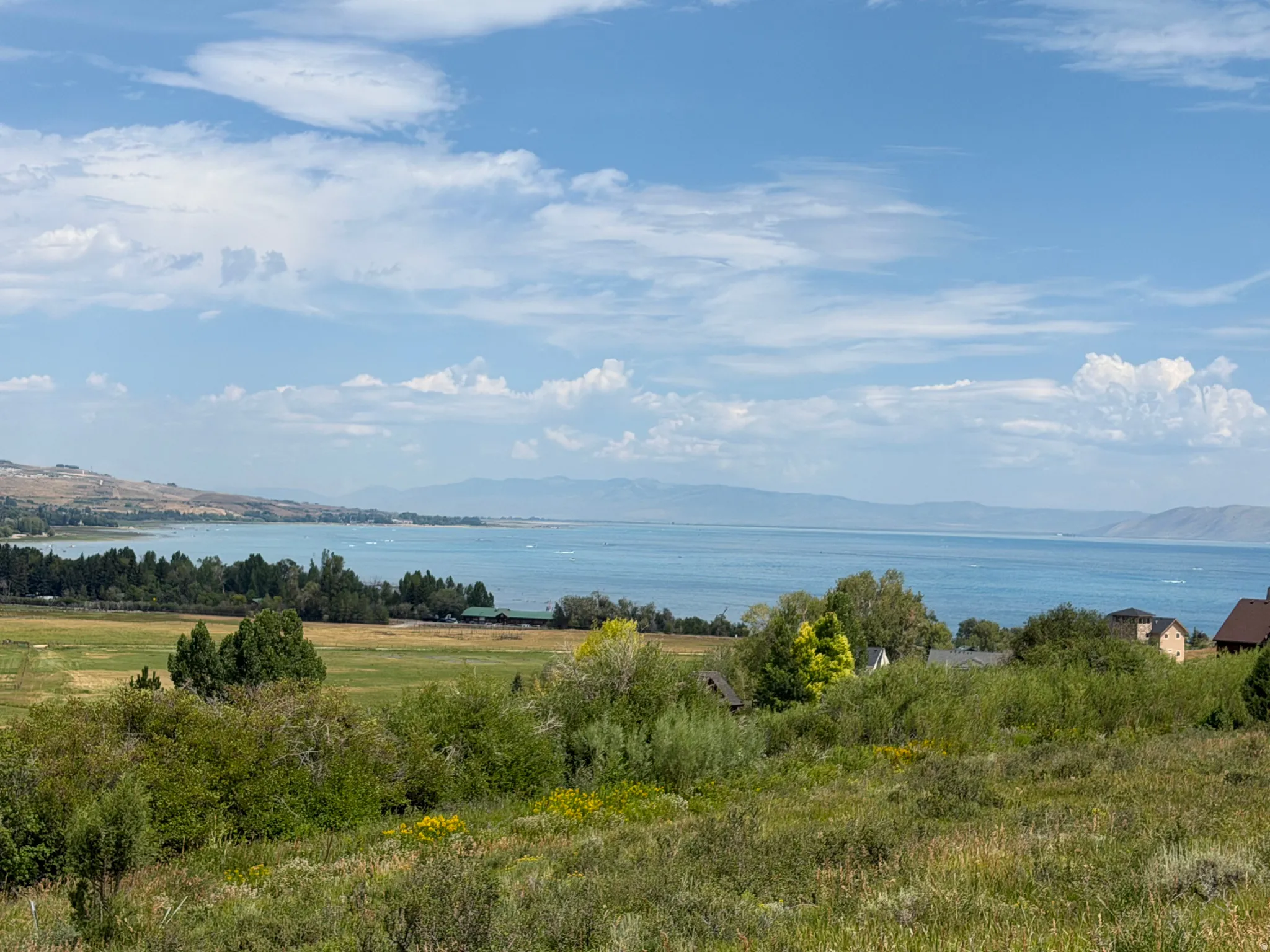 Expansive water frontage with surrounding mountain terrain and scattered residential structures