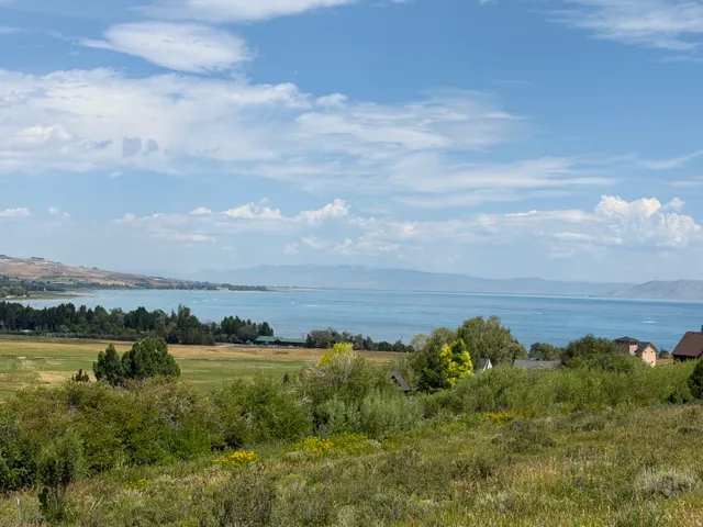 Expansive water frontage with surrounding mountain terrain and scattered residential structures