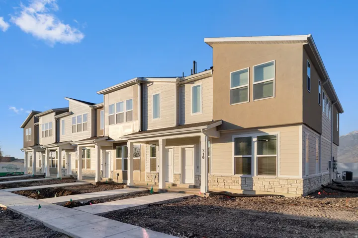 Modern multi-level townhome featuring a neutral exterior with horizontal siding and stucco accents
