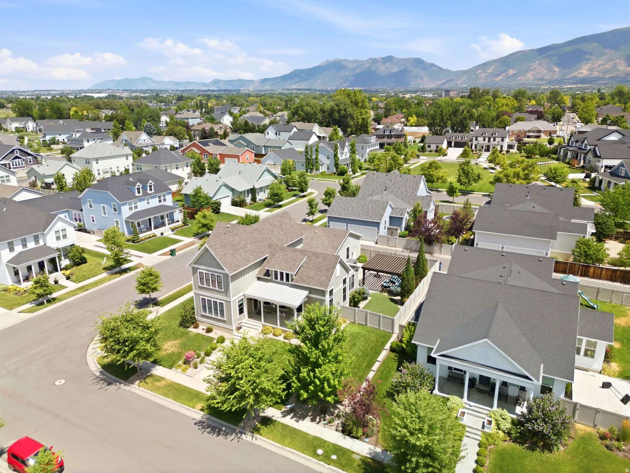 Residential neighborhood featuring broad streets, mature trees, and a mountain backdrop