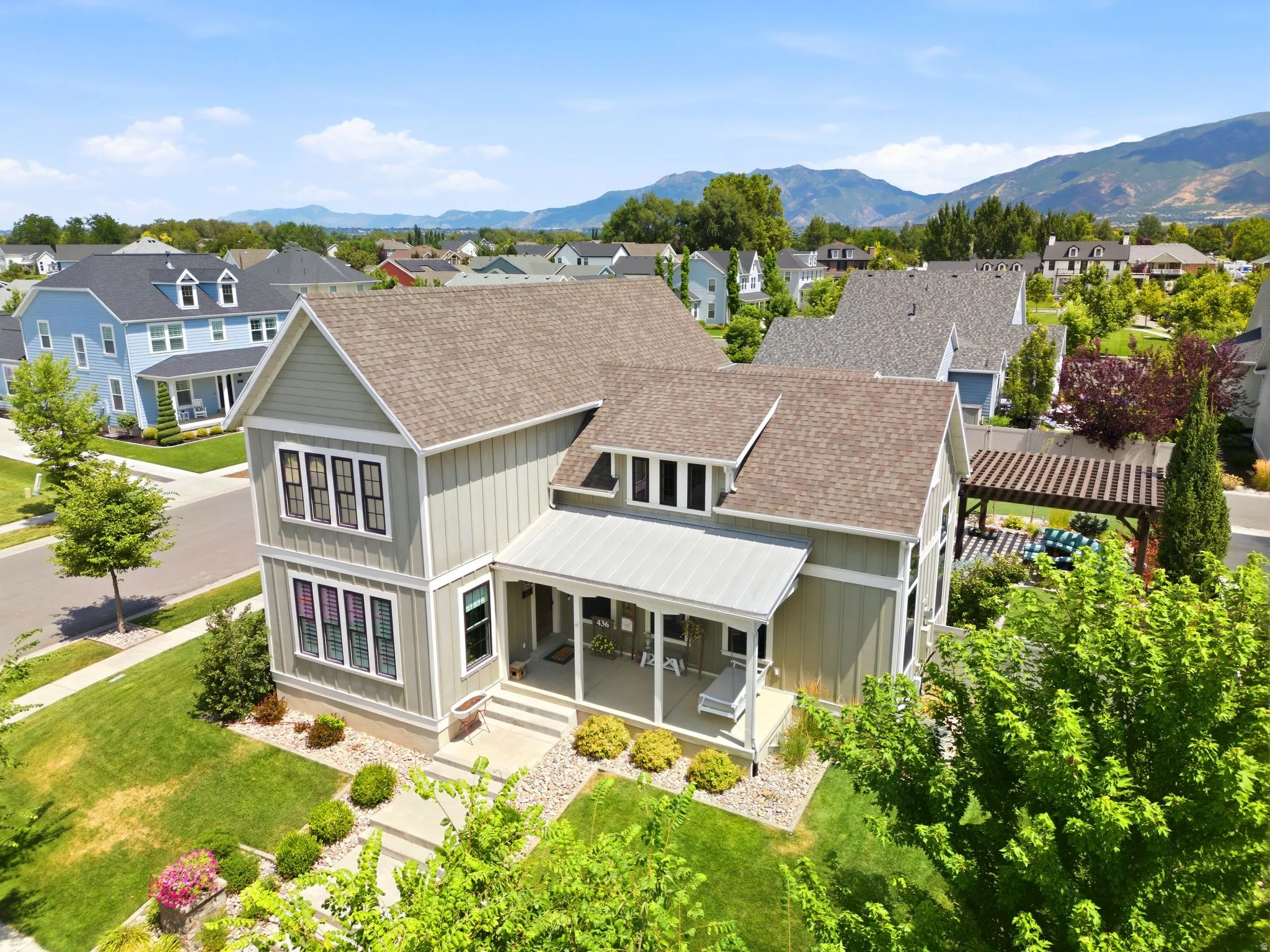 Contemporary two-story residence featuring a covered front porch, light gray siding