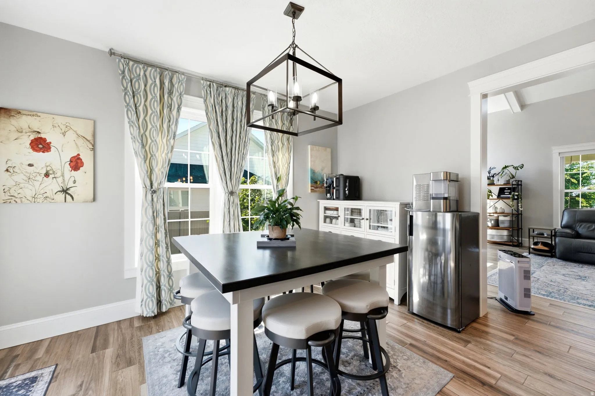 Dining area featuring wood-finish flooring, a contemporary chandelier, two large windows, view of great room