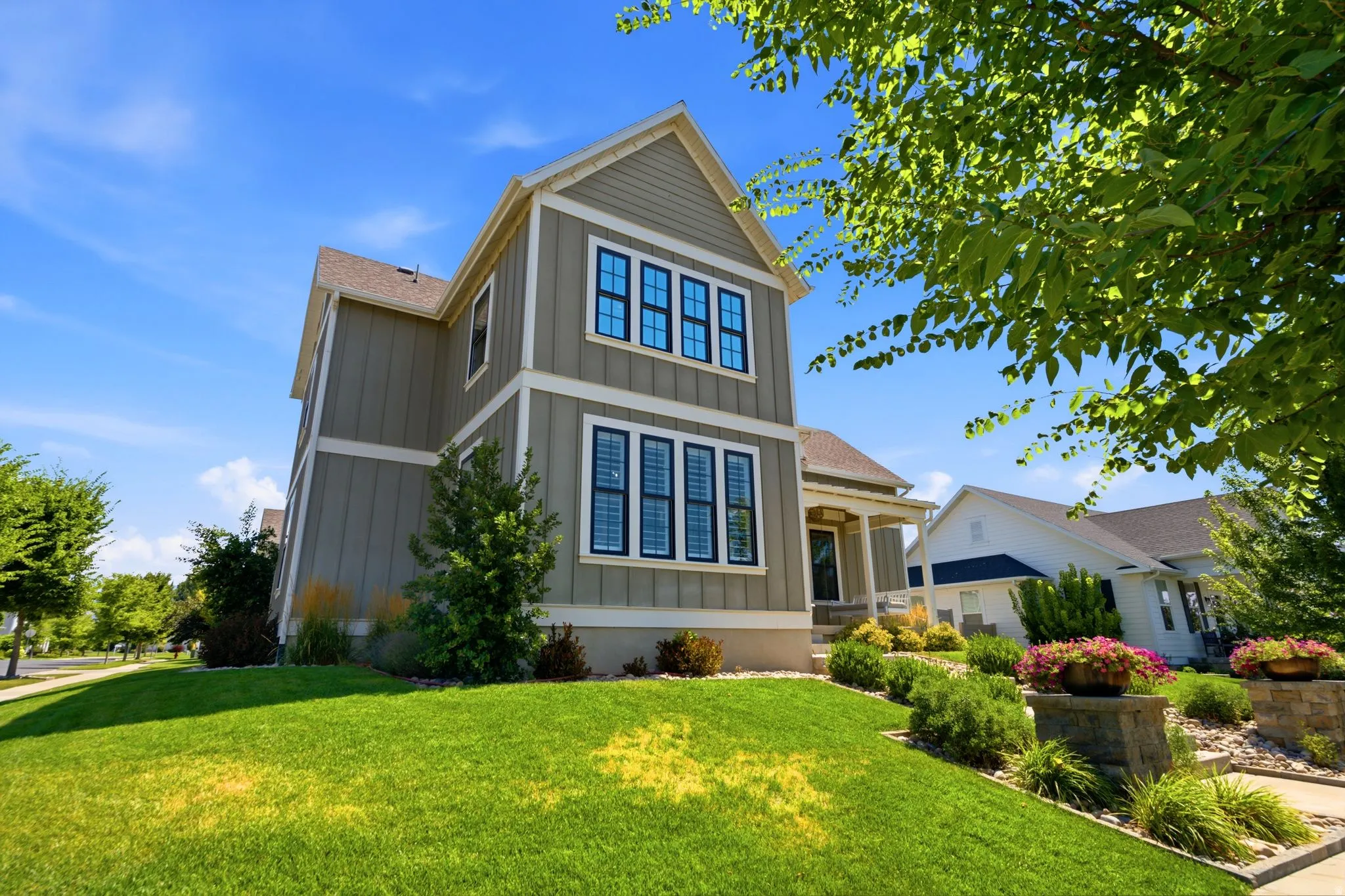 Craftsman style architecture featuring vertical board-and-batten siding with white trim and covered front porch
