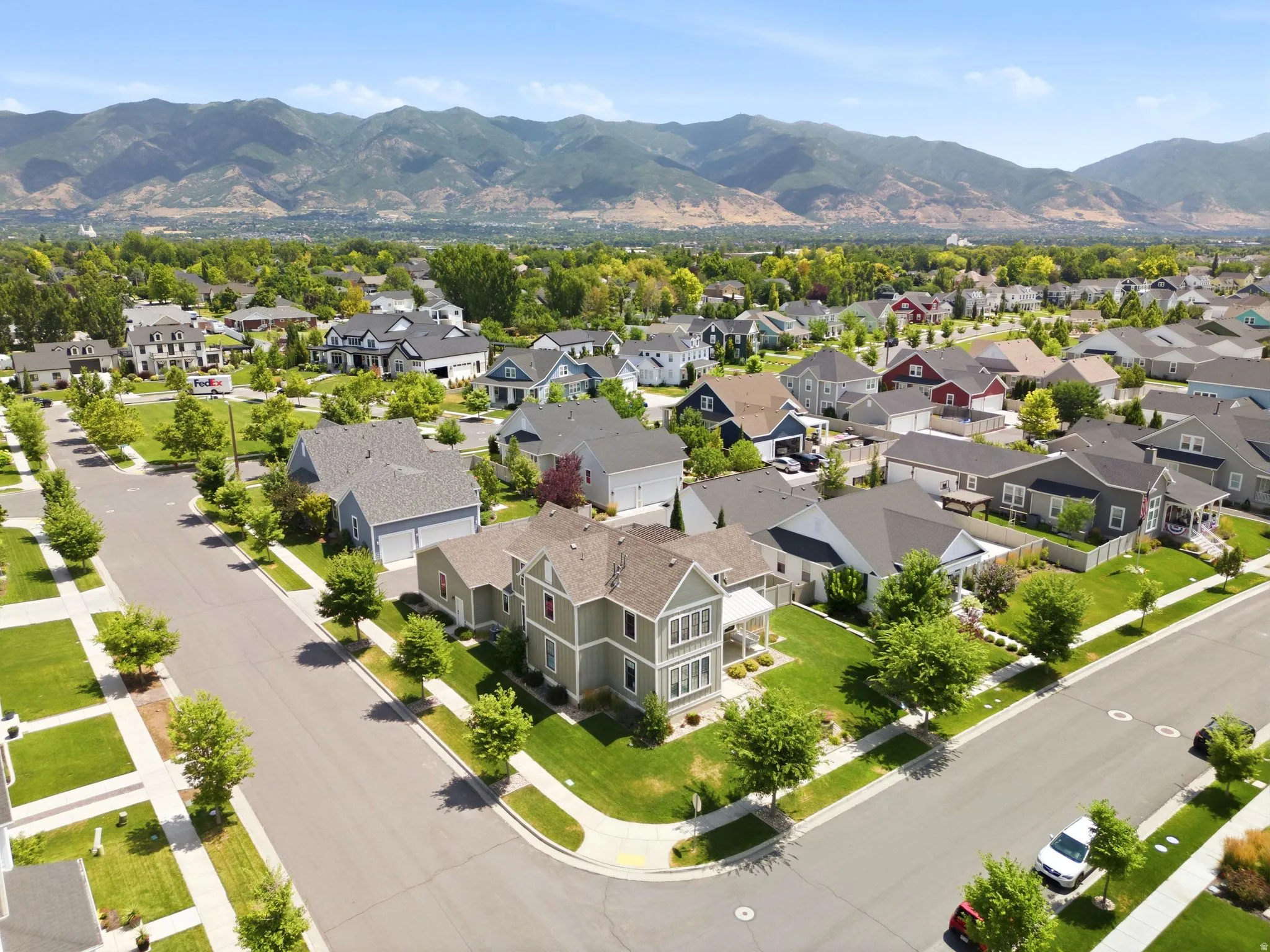 Residential neighborhood with a variety of architectural styles, mature landscaping, and mountain backdrop