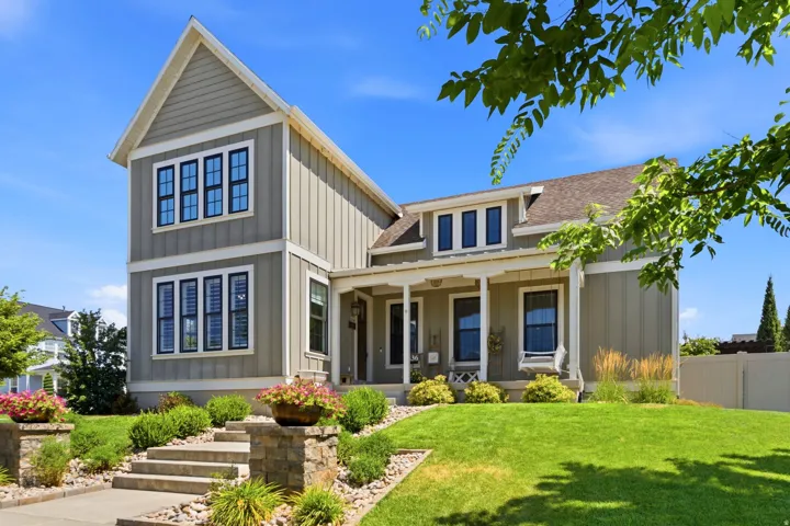Craftsman-style exterior featuring charming front porch with swing, gabled rooflines and board-and-batten siding