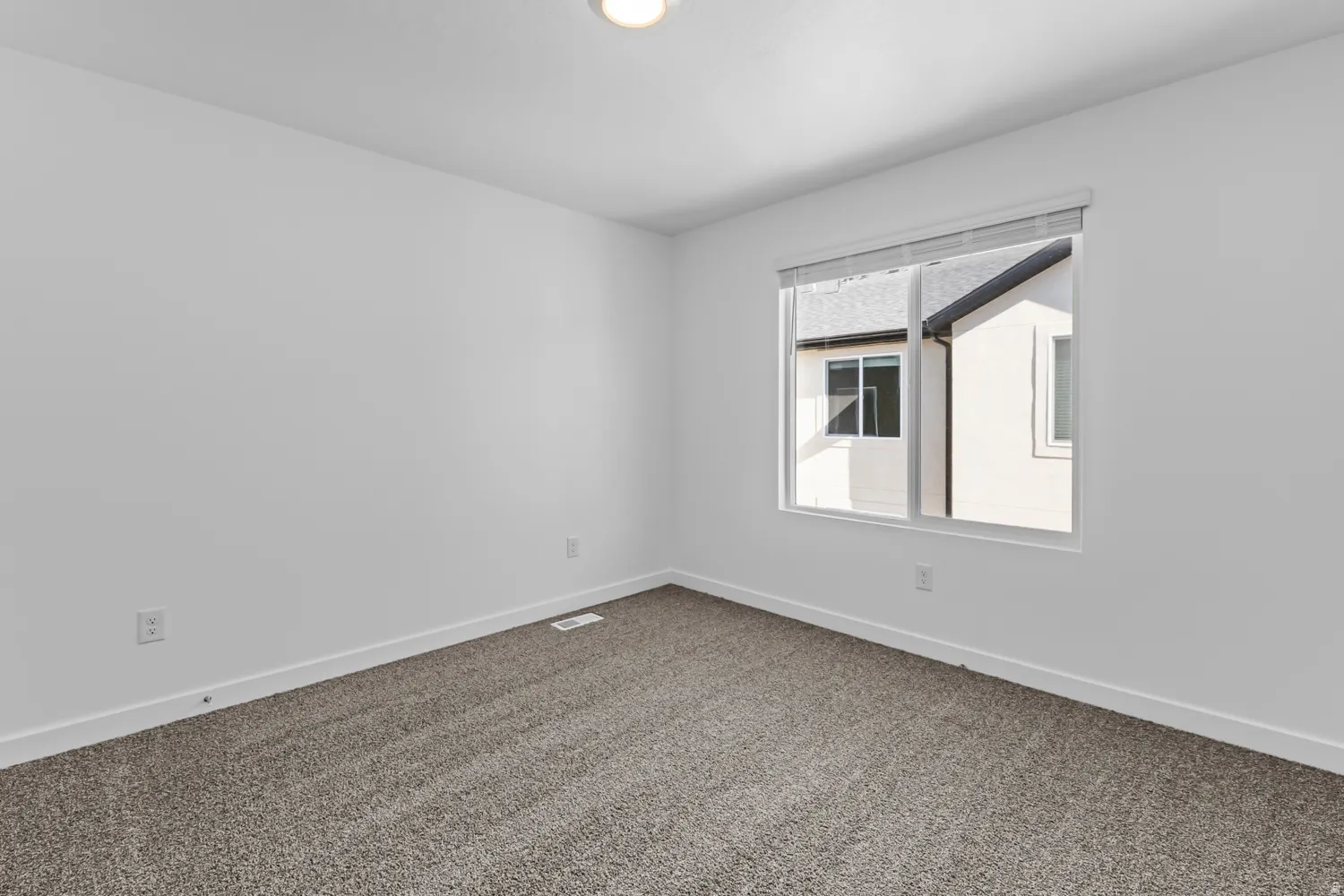 Neutral tone wall finishes, window with blinds, recessed ceiling lighting, textured carpet flooring, and white baseboards