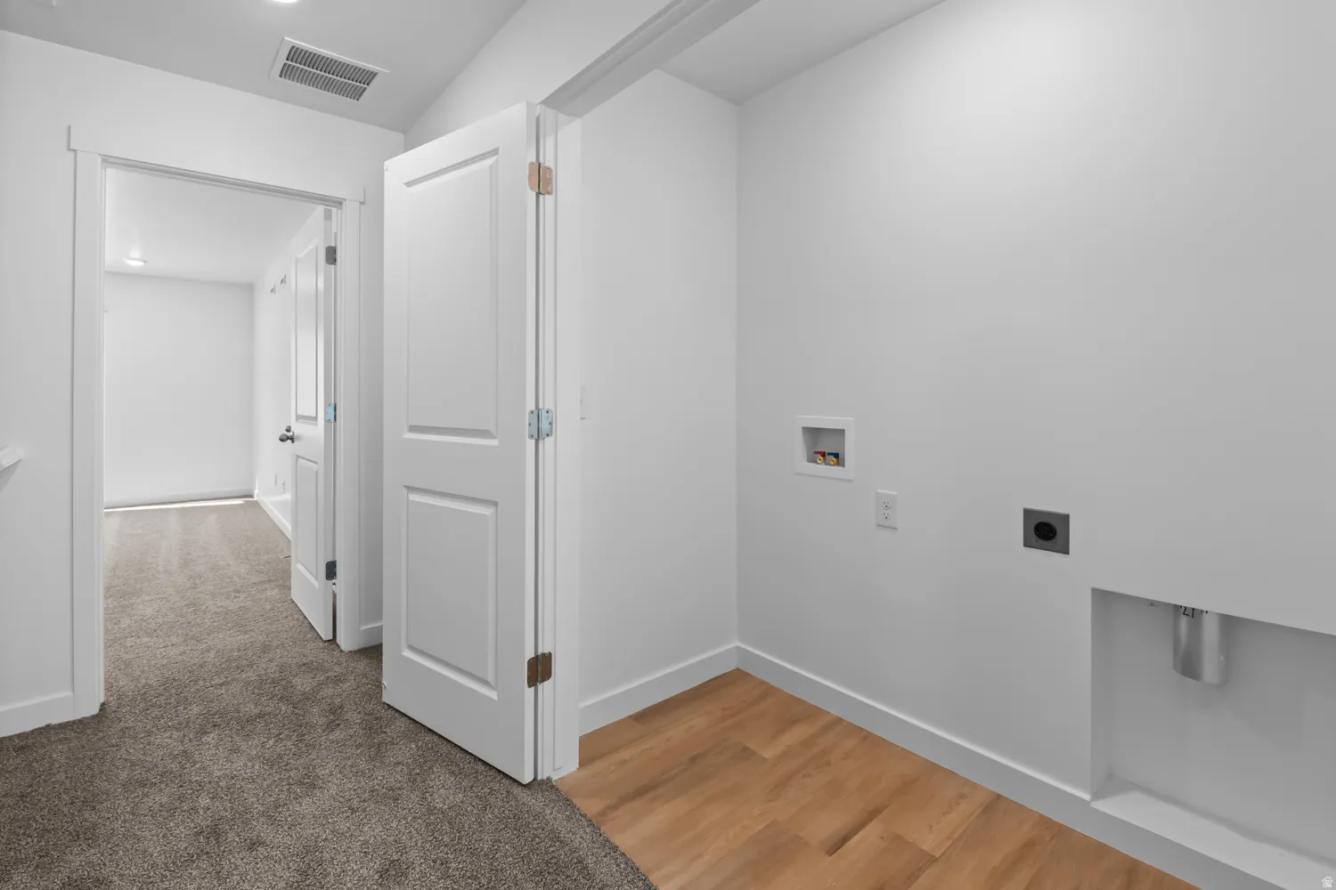 Dedicated laundry area with light wood-finish flooring