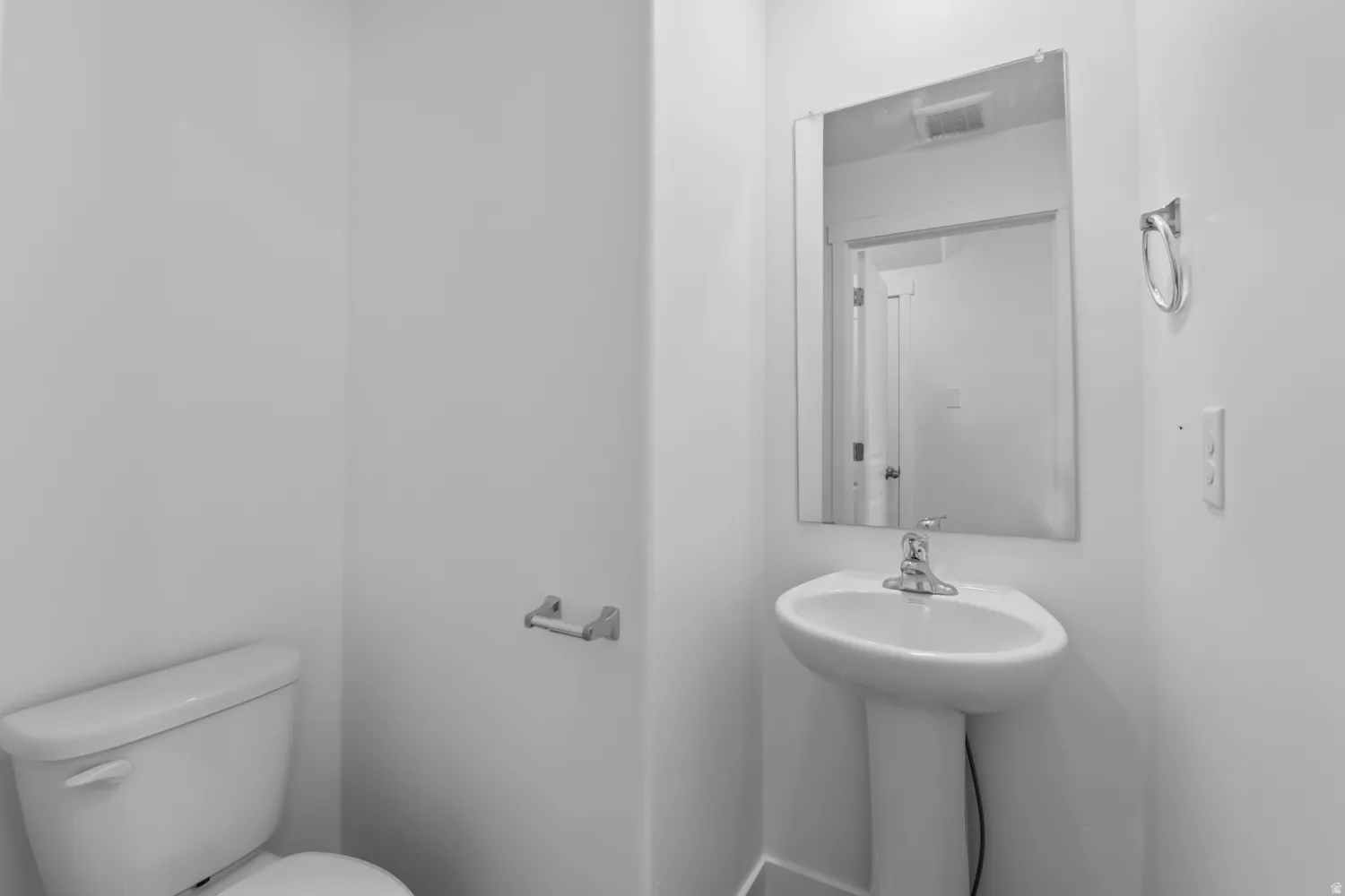 Pedestal sink with chrome-finish faucet and rectangular mirror