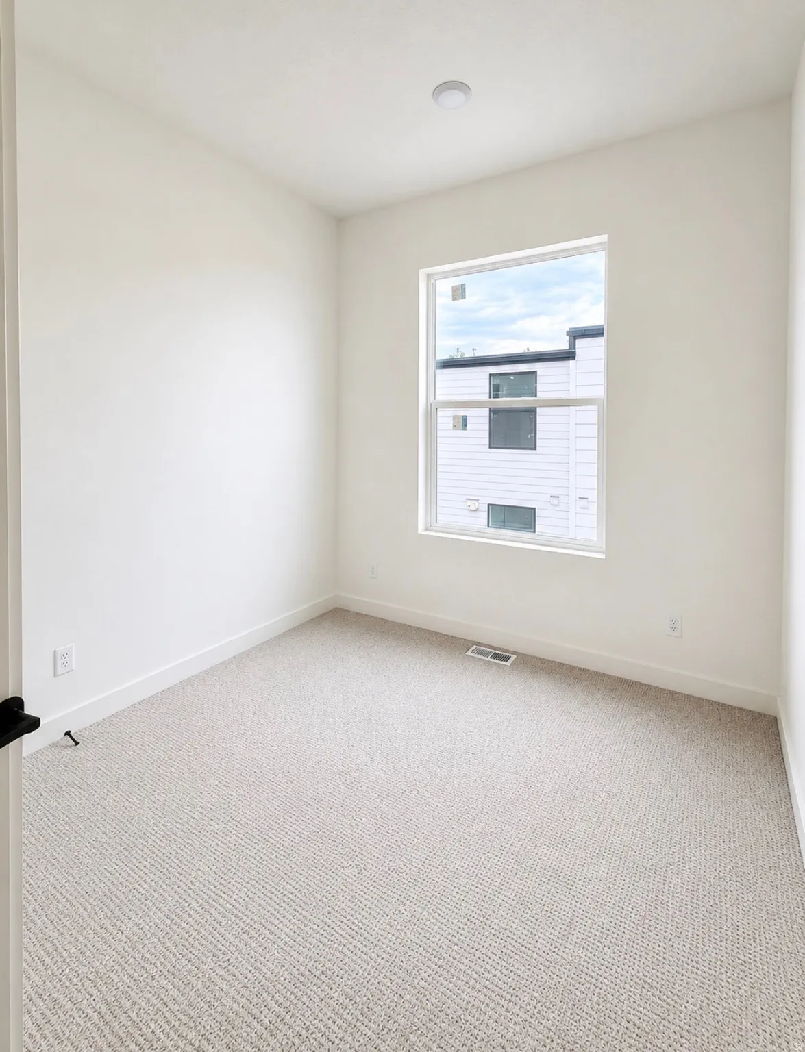 Neutral tone carpeting with white trim and walls