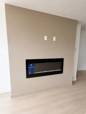 Built-in fireplace on a neutral-toned accent wall with light wood-finish flooring