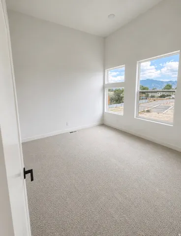Bright room featuring white walls and neutral-toned carpet