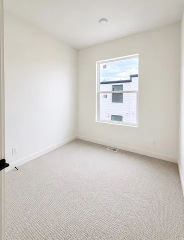 Neutral tone carpeting with white trim and walls