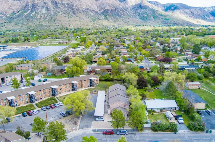 Aerial perspective showcasing a residential community with abundant mature trees and mountainous terrain
