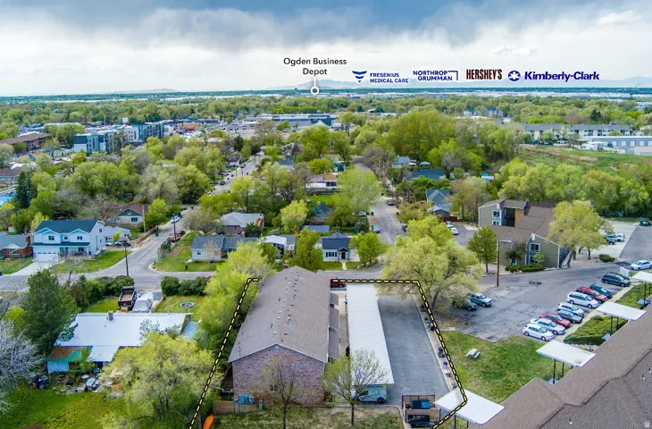 Aerial view showcasing a multi-unit property with ample paved parking