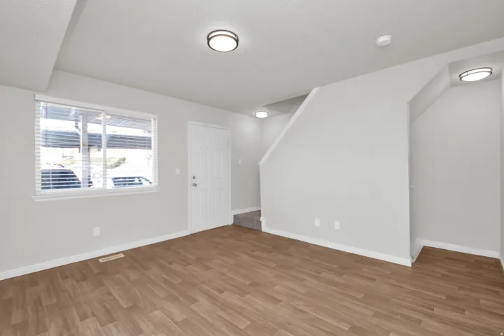 Open-concept living space featuring wood-finish flooring and neutral-toned walls