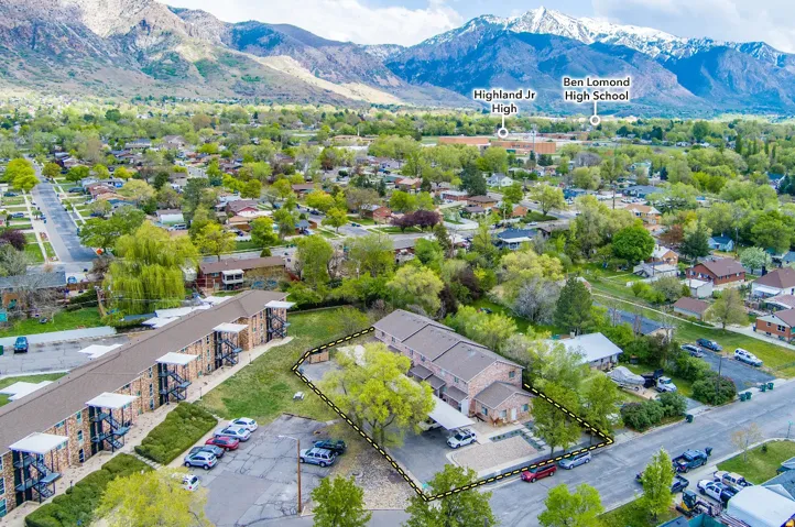 Aerial perspective showcasing a multi-unit property with a mountain backdrop