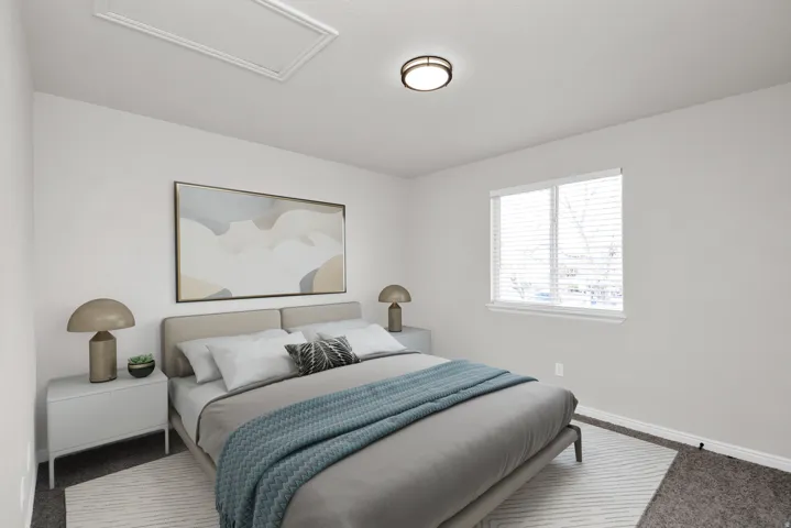 Bedroom featuring light-colored walls and a window with horizontal blinds
