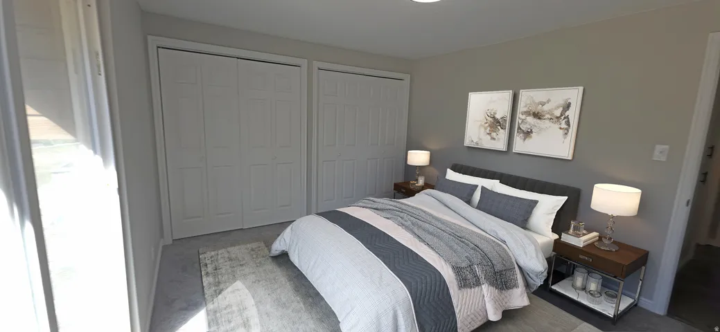 Carpeted bedroom featuring two bi-fold closet doors, recessed lighting, and a window