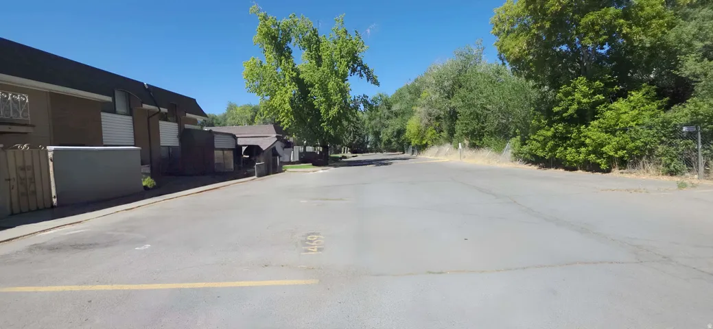 Paved parking area bordered by multiple residential structures with sloped roofs