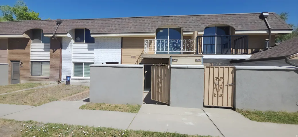 Townhome exterior featuring varied siding, arched window accents, and individual gated entryways
