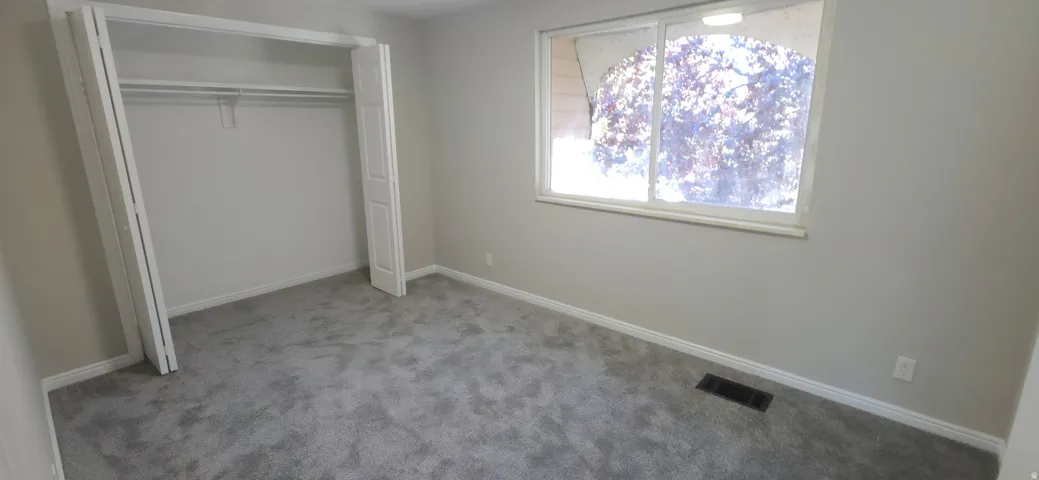 Room featuring neutral-toned walls, grey carpeting, and white trim