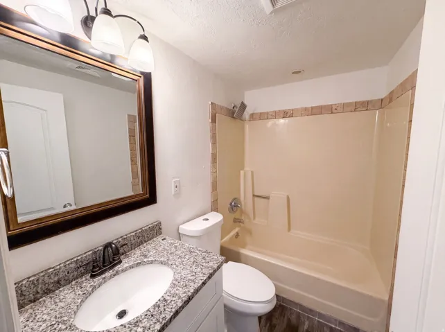 Bathroom vanity with granite-style countertop, undermount sink, and oil-rubbed bronze faucet