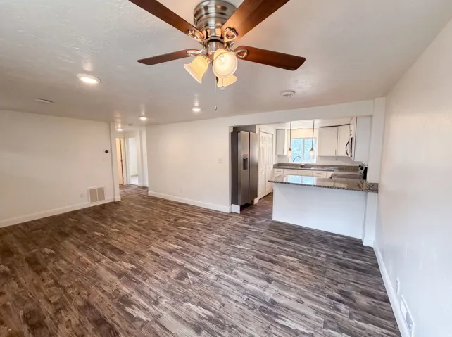 Spacious common area featuring wood-finish flooring, recessed lighting, and a ceiling fan with light fixture