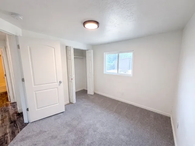 Bedroom featuring light gray carpeting and white walls
