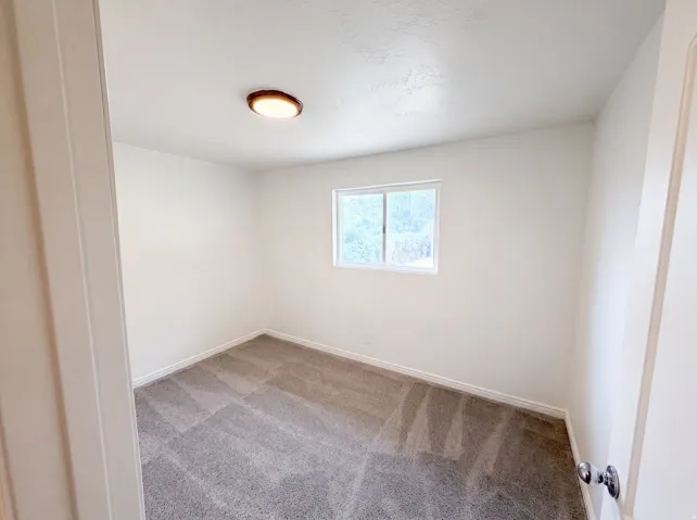 Neutral-toned room featuring a single window and recessed lighting