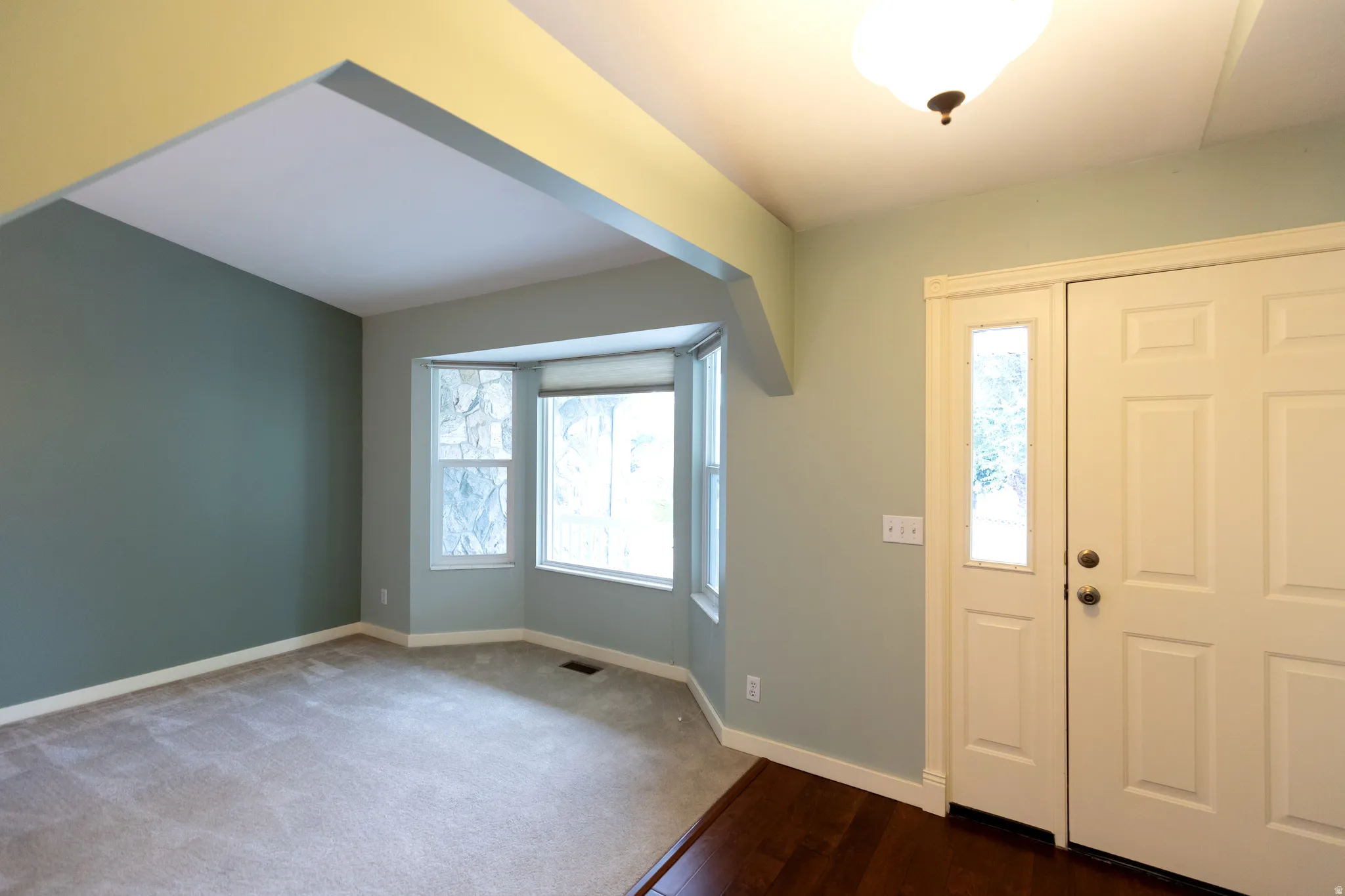 Entryway featuring a double door with sidelight, wood-finish flooring, and a flush mount ceiling light
