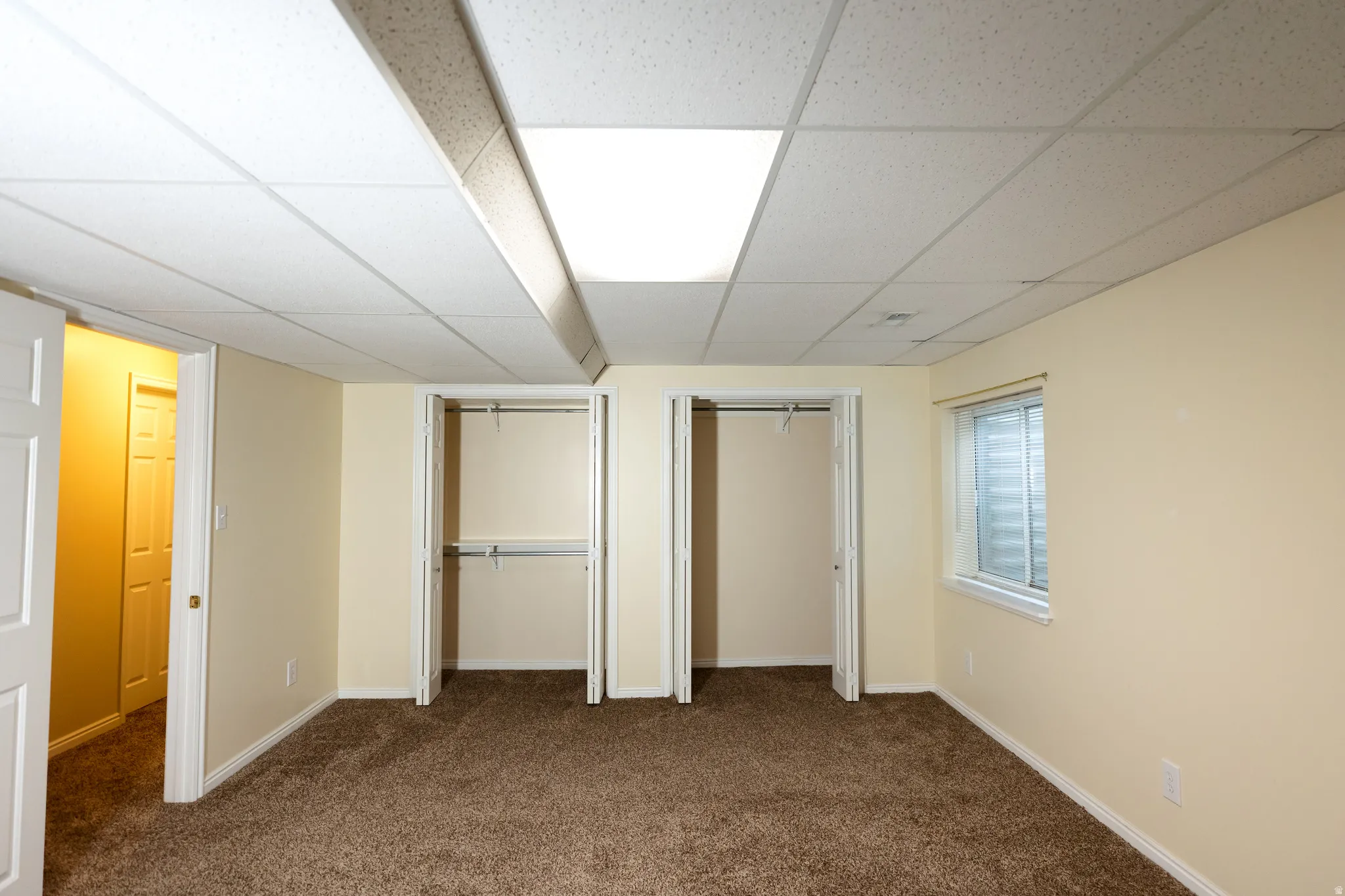 Neutral-toned room featuring plush brown carpeting and light cream walls