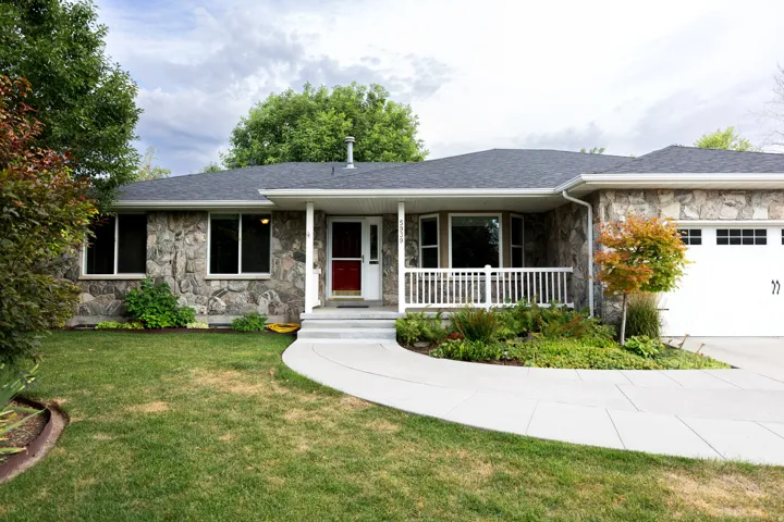 Stone facade exterior with a covered front porch featuring white railings