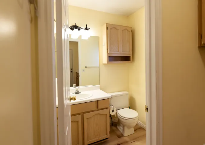 Bathroom featuring a vanity with a laminate countertop, integrated sink, and wood-finish cabinetry