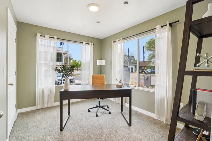 Spacious room featuring two large windows, light green painted walls, and recessed ceiling lighting