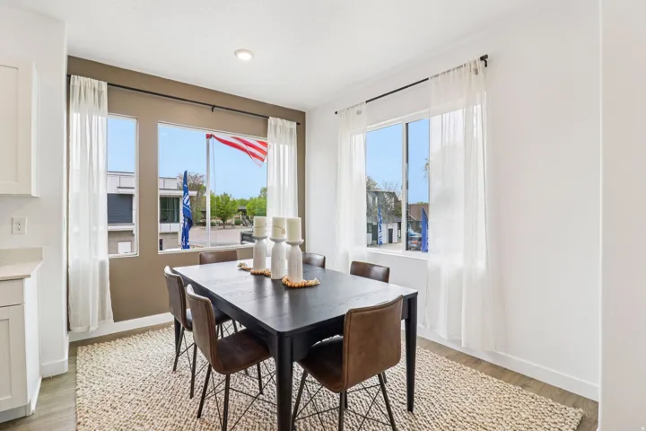 Dining area with wood-finish flooring and a textured area rug