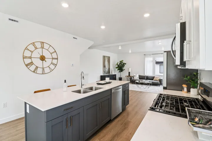 Kitchen featuring a gas range, stainless steel dishwasher, and a large island with an undermount double sink