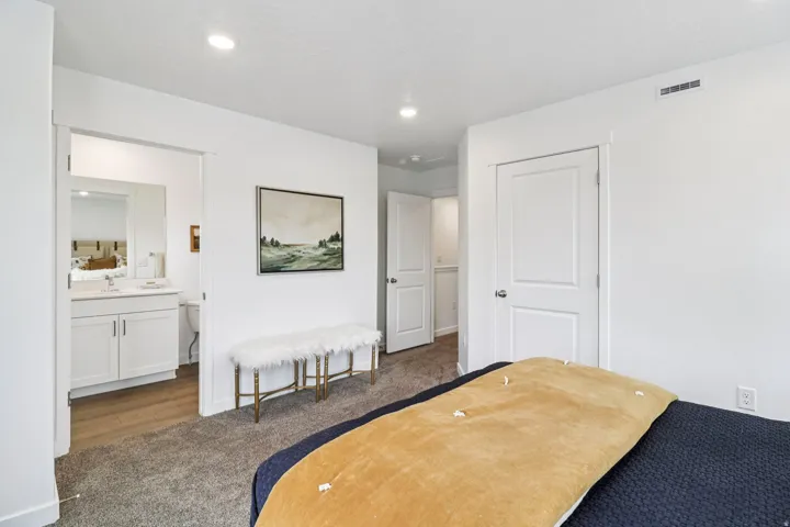 Plush gray carpeting extends throughout the room, complemented by white walls and recessed ceiling lighting