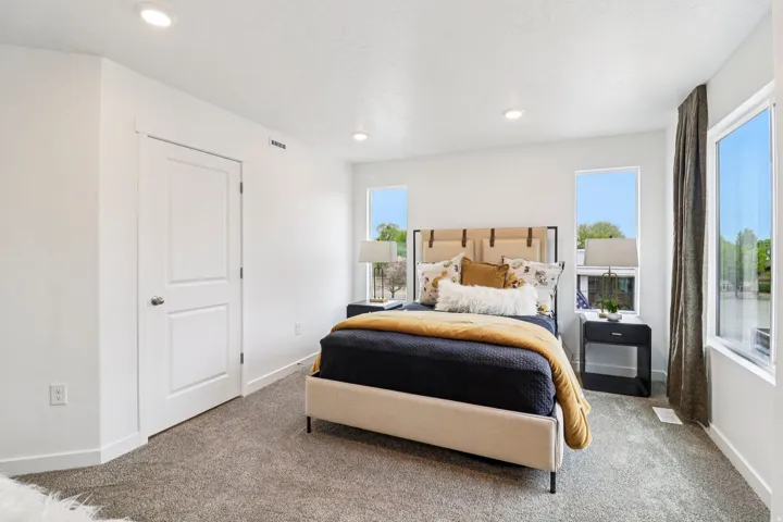 Spacious room featuring white walls, recessed lighting, and soft gray carpeting