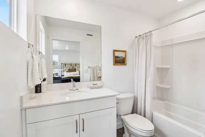 Bathroom featuring a single-sink vanity with white cabinetry, a light-toned countertop, and a chrome faucet