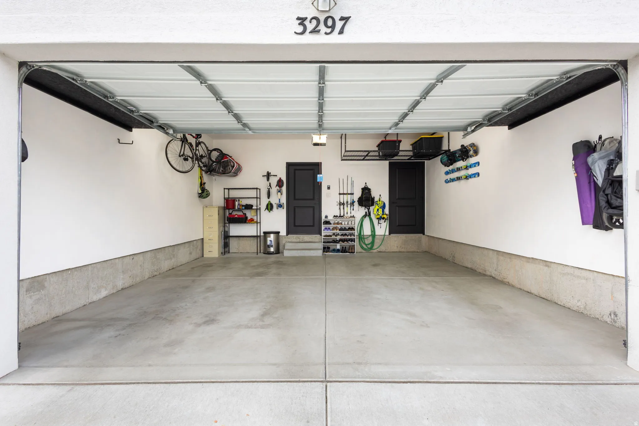 Two-car garage featuring a concrete floor, white walls, and two internal access doors